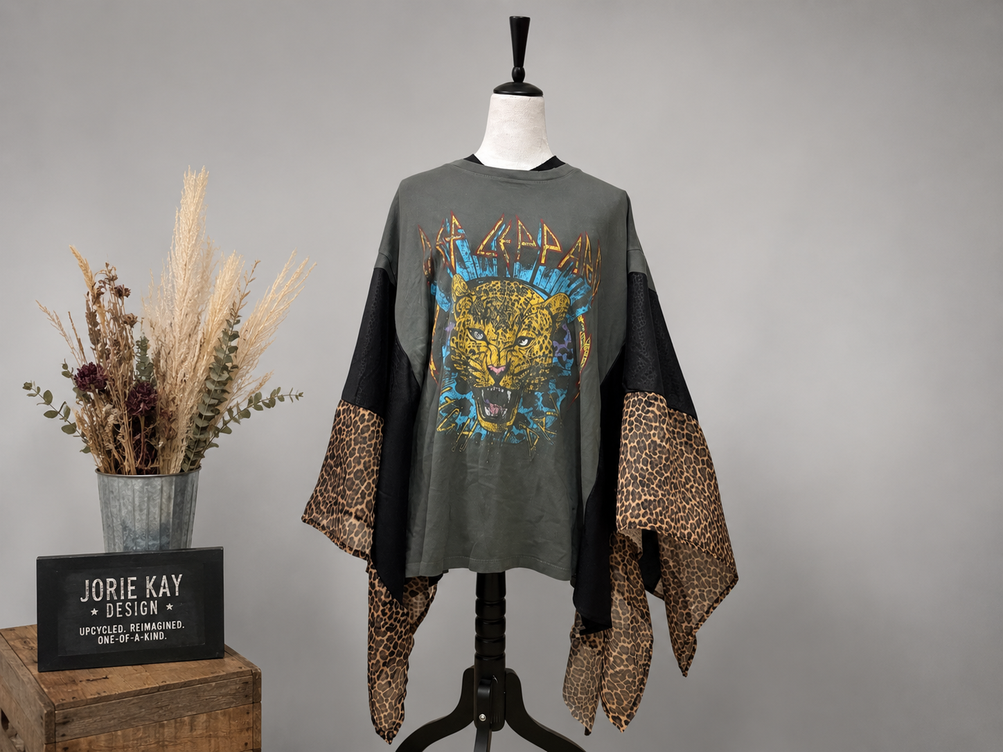 Def Leppard graphic tee poncho with leopard print accents, one-size sustainable rock style.