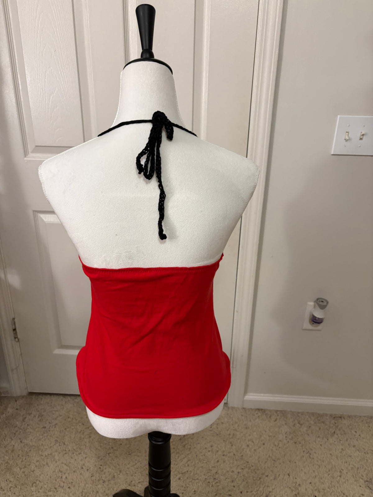 A red halter-neck UGA halter top with crocheted straps.